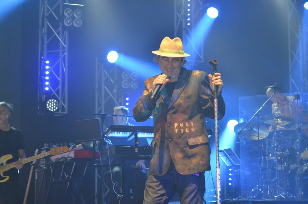 Luca Carboni live in concerto durante il tour Fisico e Politico 2013-2014, performance sul palco con luci blu e outfit personalizzato