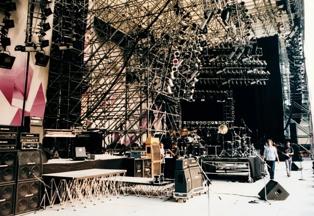 Allestimento del palco prima del concerto con strutture di rigging, americane luci, amplificatori Marshall e batteria