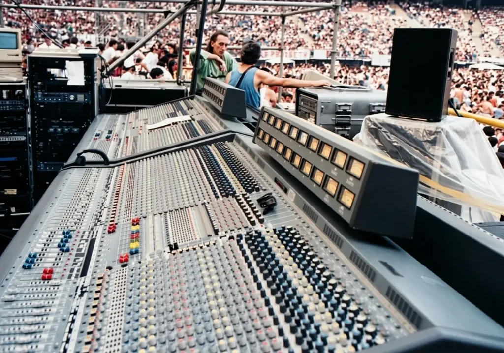 Regia audio con due console Midas XL3 linkate e il pubblico dello stadio sullo sfondo durante un concerto